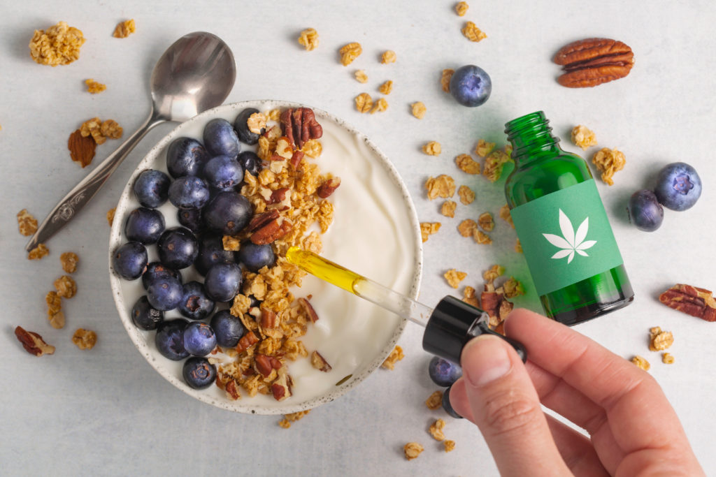 person adding CBD tincture into oatmeal; what is a tincture